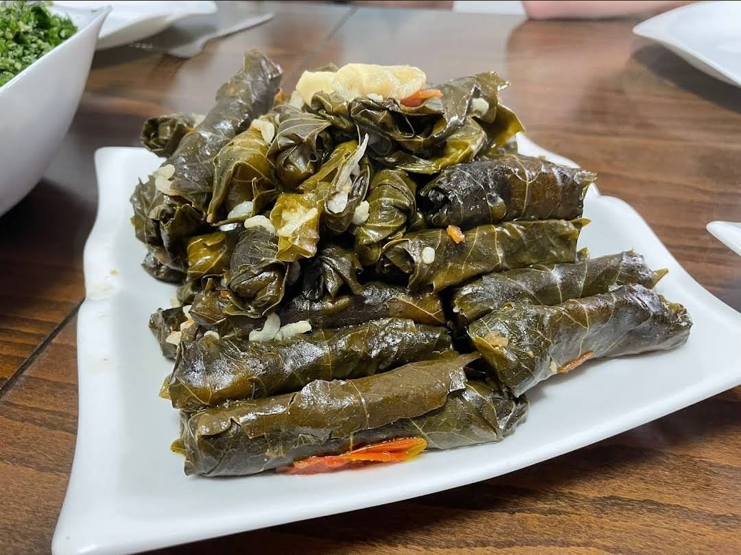 מגש לבן ובו ערימה של עלי גפן ממולאים